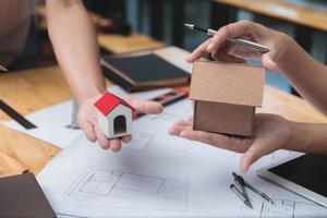 equipo de arquitectos o ingenieros discutiendo en el escritorio con planos sobre el nuevo proyecto de inicio en el escritorio. grupo de equipo en los documentos de verificación del sitio de construcción y el flujo de trabajo comercial. enfoque selectivo. foto