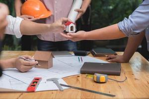 Team of architects or engineer discussing on desk with blueprint about new startup project on desk. Team group on construciton site check documents and business workflow.Selective focus. photo