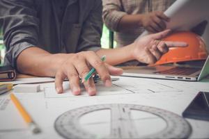 Team of architects or engineer discussing on desk with blueprint about new startup project on desk. Team group on construciton site check documents and business workflow.Selective focus. photo