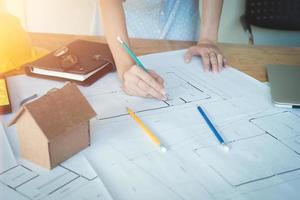 mujer arquitecta sola que trabaja con brújulas y planos para el plan arquitectónico, ingeniera que esboza un concepto de proyecto de construcción.concepto de arquitecto,efecto vintage foto