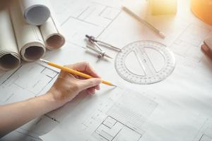 Alone architect woman working with compasses and blueprints for architectural plan,engineer sketching a construction project concept.Architect concept,Vintage Effect photo