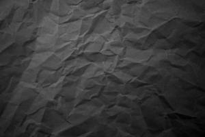 Textured crumpled black paper background. photo