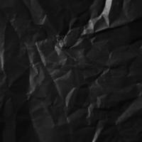 Textured crumpled black paper background. photo