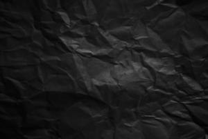 Textured crumpled black paper background. photo