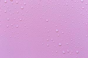 gotas de agua sobre un fondo rosa. como una gota de fondo en el producto. foto