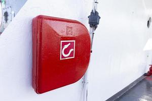 Red fire hose reel attached to the wall on the boat. photo