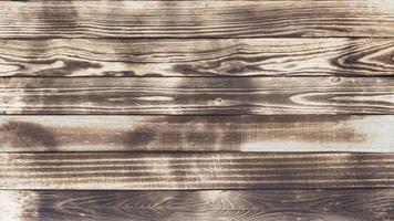 el suelo de madera con rastros de quemado hace un fondo y una textura abstractos negros. foto