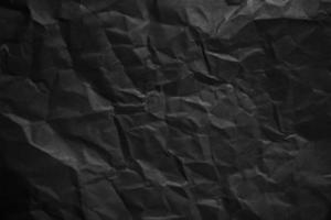 Textured crumpled black paper background. photo