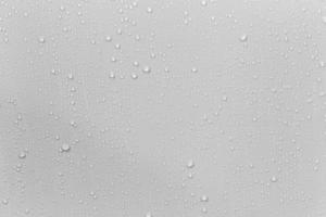 The concept of raindrops falling on a gray background Abstract wet white surface with bubbles on the surface Realistic pure water droplet water drops for creative banner design photo