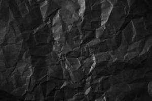 Textured crumpled black paper background. photo