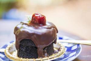 Chocolate cake with red strawberries on top makes it look appetizing. photo