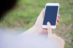 Closeup of female hand using a mobile phone on farm background photo