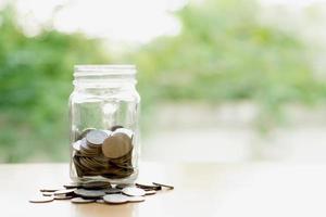 Savings word with money coin in glass jar.financial concept