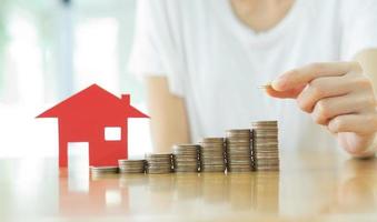 Real estate investment. House and coins on table. photo