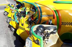 famosos y coloridos taxis de coco en la habana esperando a los turistas para dar un paseo en un auto antiguo por las principales atracciones de la ciudad foto