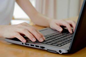 programmer's hand typing with laptop. focus on his finger photo