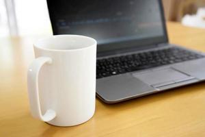 Laptop and coffee cup on wood table. View from above photo
