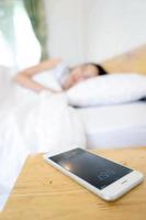 Sleeping Woman Being Woken By Mobile Phone In Bedroom photo