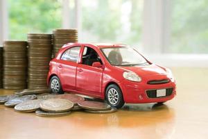 red car over a lot of stacked coins photo