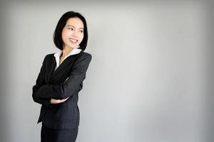 Portrait young business woman standing against grey background photo