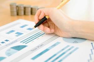 Businesswoman Analyzing Financial Graph With Coins photo