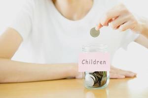 Woman hands with coins in glass jar, close up photo