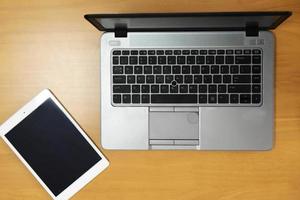 View of a Laptop in high definition with tablet and mobile on a wood background photo