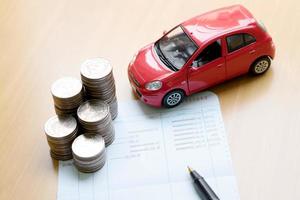 Rows of coins, account book, car. Finance and banking concept. photo