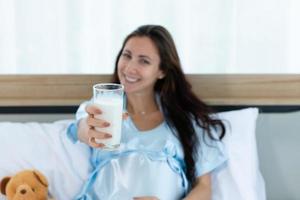 Pregnant woman in bedroom with morning atmosphere with milk photo