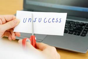 holds card with text unsccess on computer photo