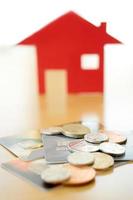 inversión inmobiliaria con tarjeta de crédito. casa y monedas foto