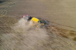 Top view of tractor planting corn seed in field, high angle view drone photography photo