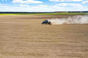side view of tractor planting corn seed in field, high angle view drone photography photo