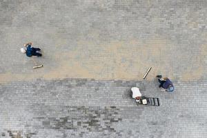 los trabajadores ponen losas de pavimentación vista superior foto