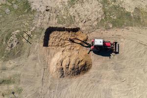 una excavadora cava un agujero en un sitio de construcción foto