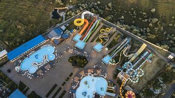 Aerial view of public outdoor swimming pool with water slide.