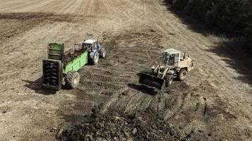 Dredger with natural manure loading trailer for field fertilization. Agricultural machine for fertilizing. Cow Dung photo