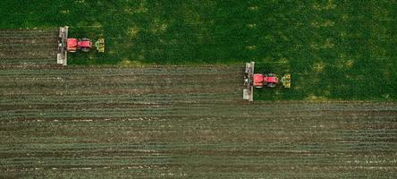 dos tractores cortan un campo de fotografía aérea con drones foto