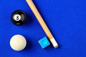 Billiard balls, cue and chalk on a blue pool table. Viewed from above. Horizontal image. photo