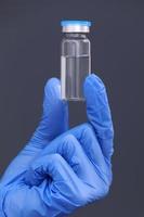 Development and creation of a coronavirus vaccine COVID-19 .Coronavirus Vaccine in glass bottle in hand of doctor on gray background. Vaccine Concept of fight against coronavirus. photo