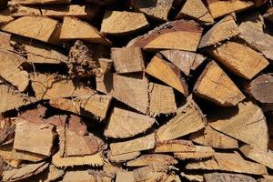 texture of pine firewood. Chipped firewood is on the heap. Woodpile of firewood close-up. A stack of dry firewood, visible texture and cracks in the tree. selective focus. photo
