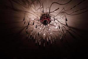 Chandelier.Home, beautiful chandelier.A luxurious lamp hangs from the ceiling. handelier with crystal.Chandelier ceiling lights, black background with copy space.Close Up. photo