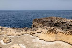 Texture of Volcanic rock surface in Cyprus look like moon surface. cliff, sea and sky background. selective focus photo