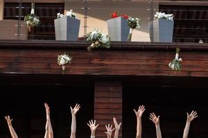 bride and bridesmaids throwing bouquets up, joyful moment. bride with girls having fun in wedding morning photo