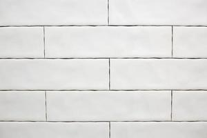Rectangular white ceramic tile on the kitchen wall. Repairs in the kitchen. Stylish trendy white ceramic tiles. Renovation of apartments and bathrooms. photo