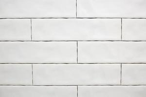 Rectangular white ceramic tile on the kitchen wall. Repairs in the kitchen. Stylish trendy white ceramic tiles. Renovation of apartments and bathrooms. photo