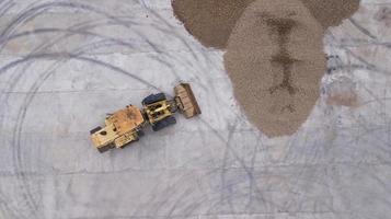 the loader loads the potatoes top view from the drone photo