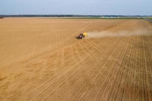 tractor sows wheat in the field top view photo