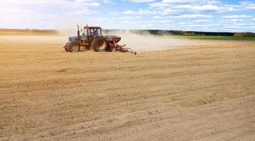 Farmer seeding, sowing crops at field. Sowing is the process of planting seeds in the ground as part of the early spring time agricultural activities. photo