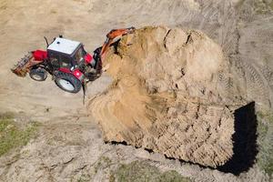 Excavator at work trenching at a construction site. Arial view. photo